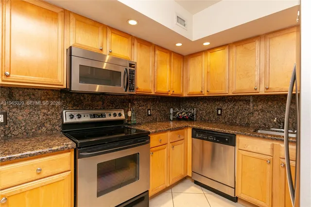 a kitchen with stainless steel appliances granite countertop a stove microwave and cabinets