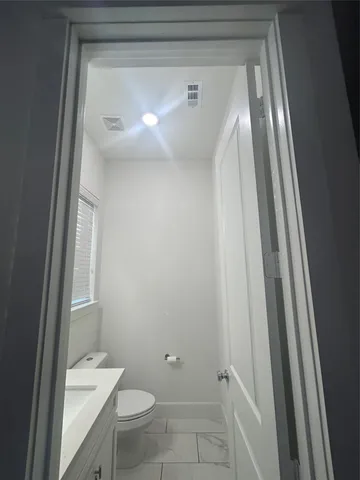 a bathroom with a granite countertop toilet and a sink