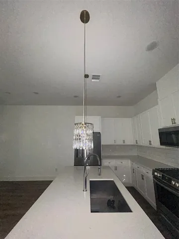 a kitchen with a sink stove and cabinets