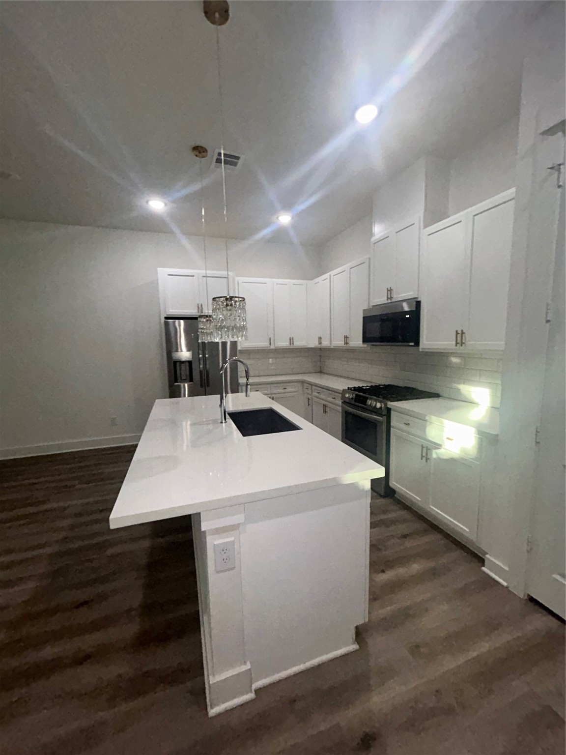 4605 Lavatera Street Houston, TX 77018 - Photo 21 of 50 a kitchen with kitchen island a sink dishwasher a stove and white cabinets with wooden floor