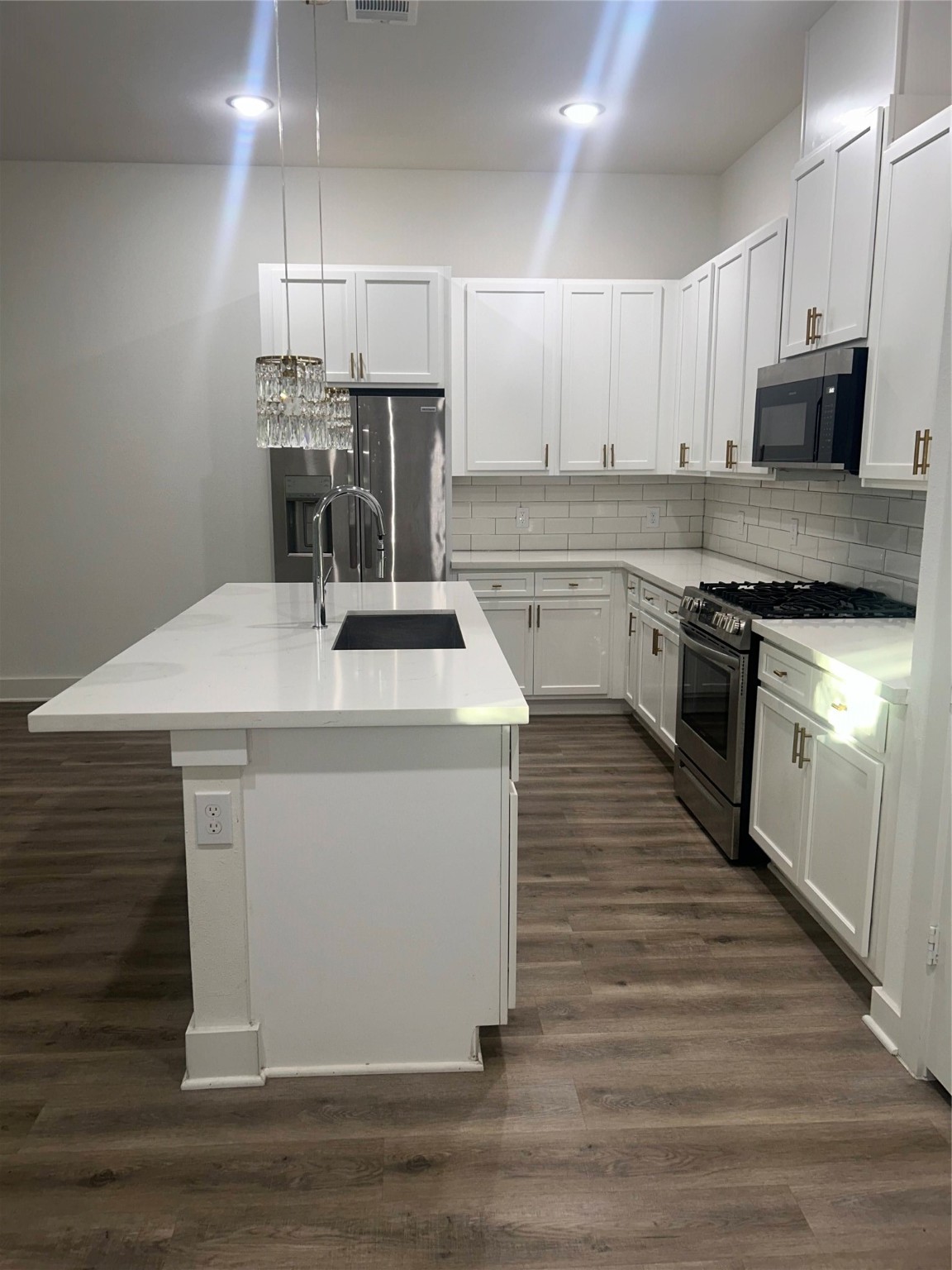4605 Lavatera Street Houston, TX 77018 - Photo 31 of 50 a kitchen with stainless steel appliances kitchen island granite countertop a stove a sink and white cabinets
