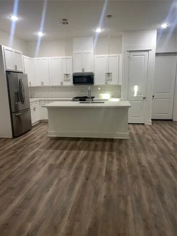 a large kitchen with kitchen island sink stove and white cabinets
