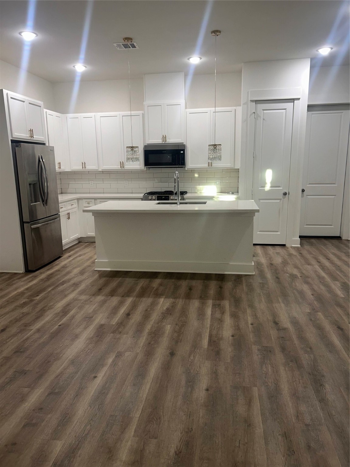4605 Lavatera Street Houston, TX 77018 - Photo 34 of 50 a large kitchen with kitchen island white cabinets and stainless steel appliances