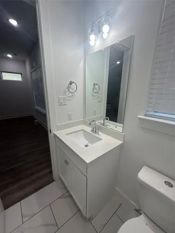 a bathroom with a sink toilet and mirror