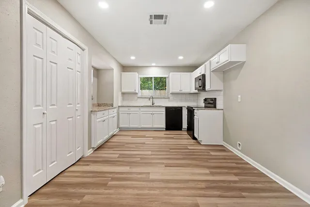 a large white kitchen with white cabinets