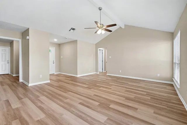 a view of empty room with wooden floor