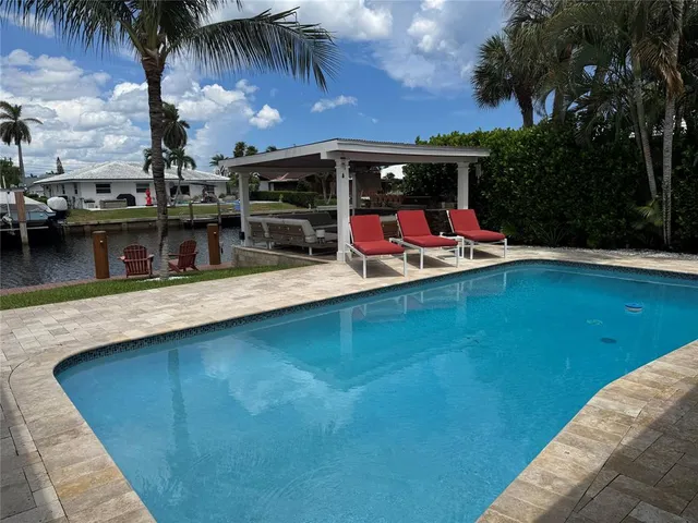 a view of a swimming pool with a table and chairs under an umbrella