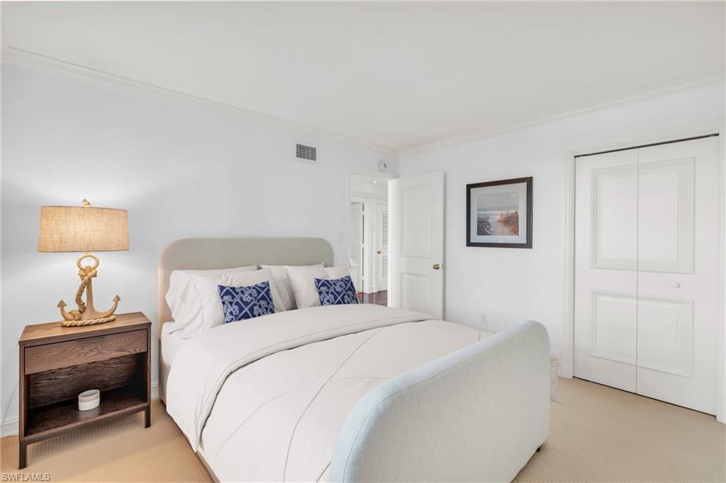 271 Broad Avenue South, Unit 202 Naples, FL 34102 - Photo 11 of 18 a bedroom with a bed and a lamp
