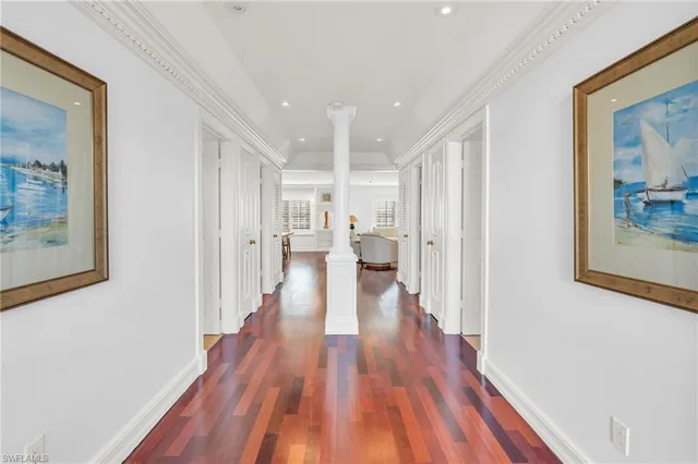 a view of a hallway with wooden floor and furniture