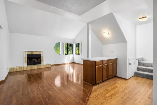 wooden floor in an empty room with a fireplace and wooden floor