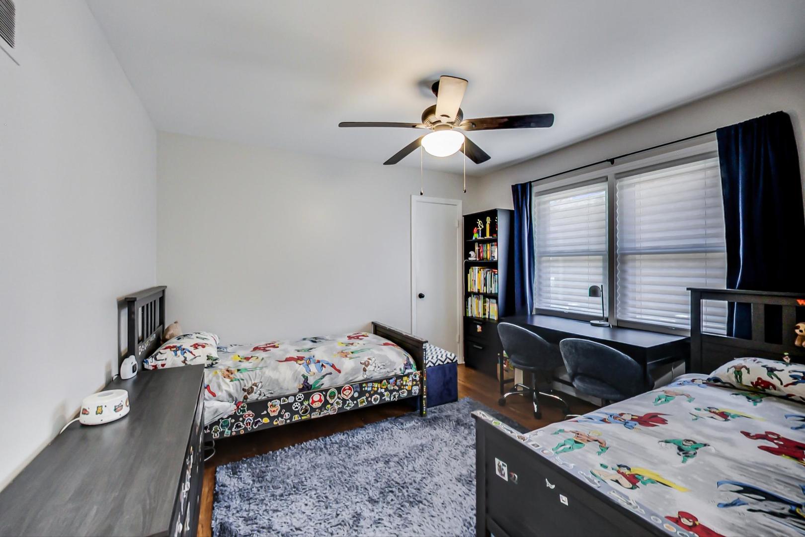 7524 East Prairie Road Skokie, IL 60076 - Photo 23 of 55 a bedroom with a bed and a chandelier