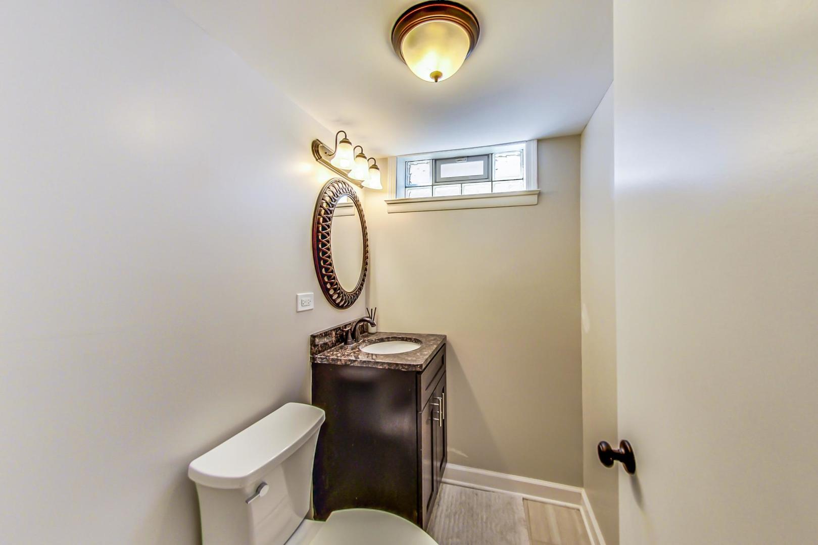 7524 East Prairie Road Skokie, IL 60076 - Photo 36 of 55 a bathroom with a toilet mirror vanity and a sink