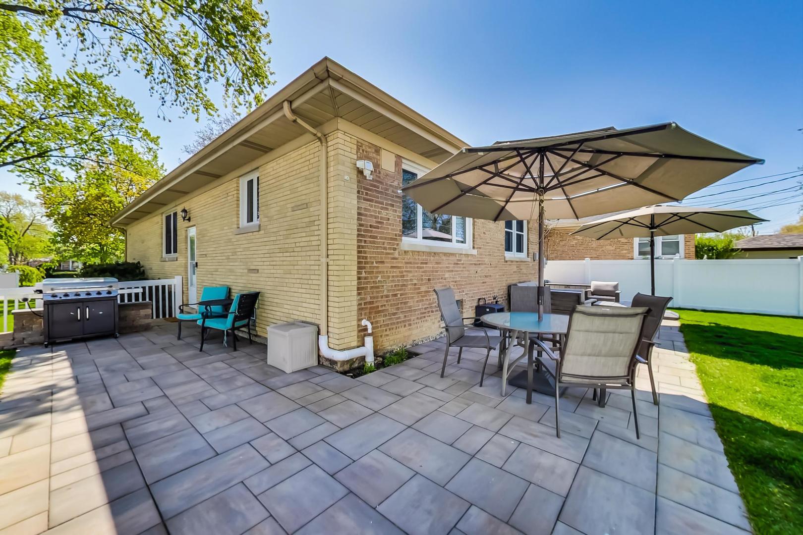 7524 East Prairie Road Skokie, IL 60076 - Photo 47 of 55 a view of a patio with table and chairs under an umbrella