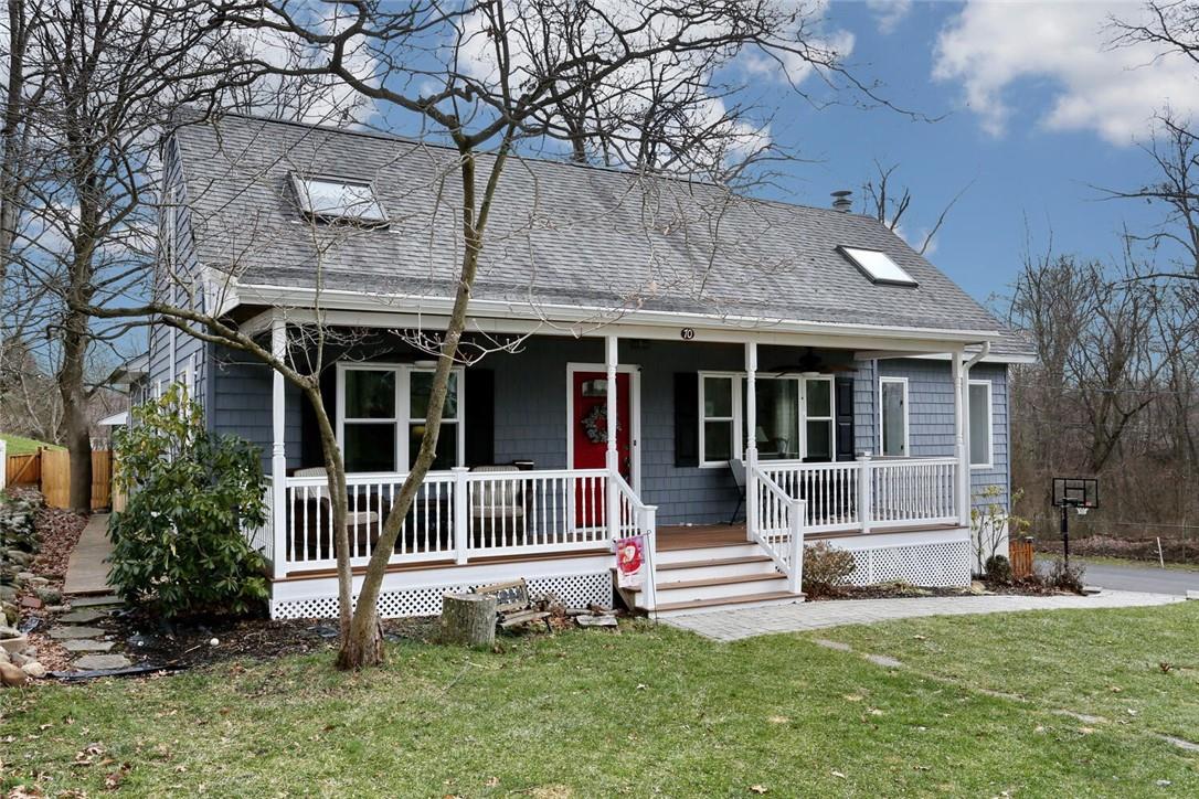 a view of a house with a yard and a large tree