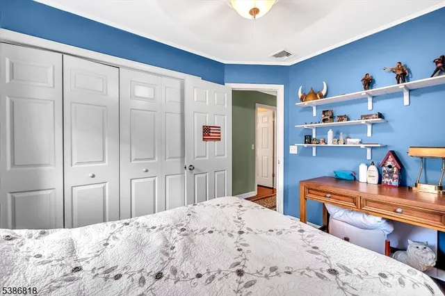 a bedroom with bed and wooden floor