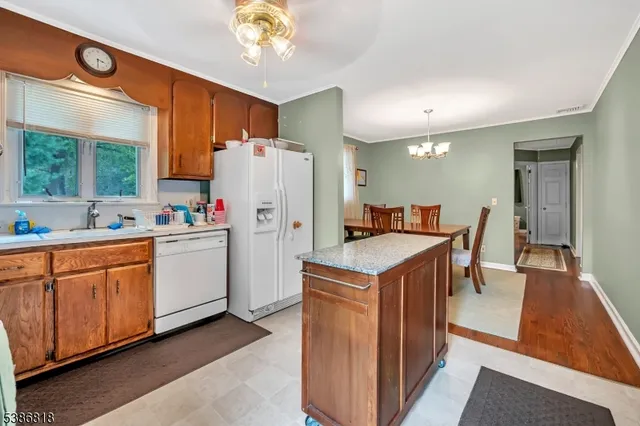 a kitchen with a refrigerator a sink dishwasher with a dining table and chairs
