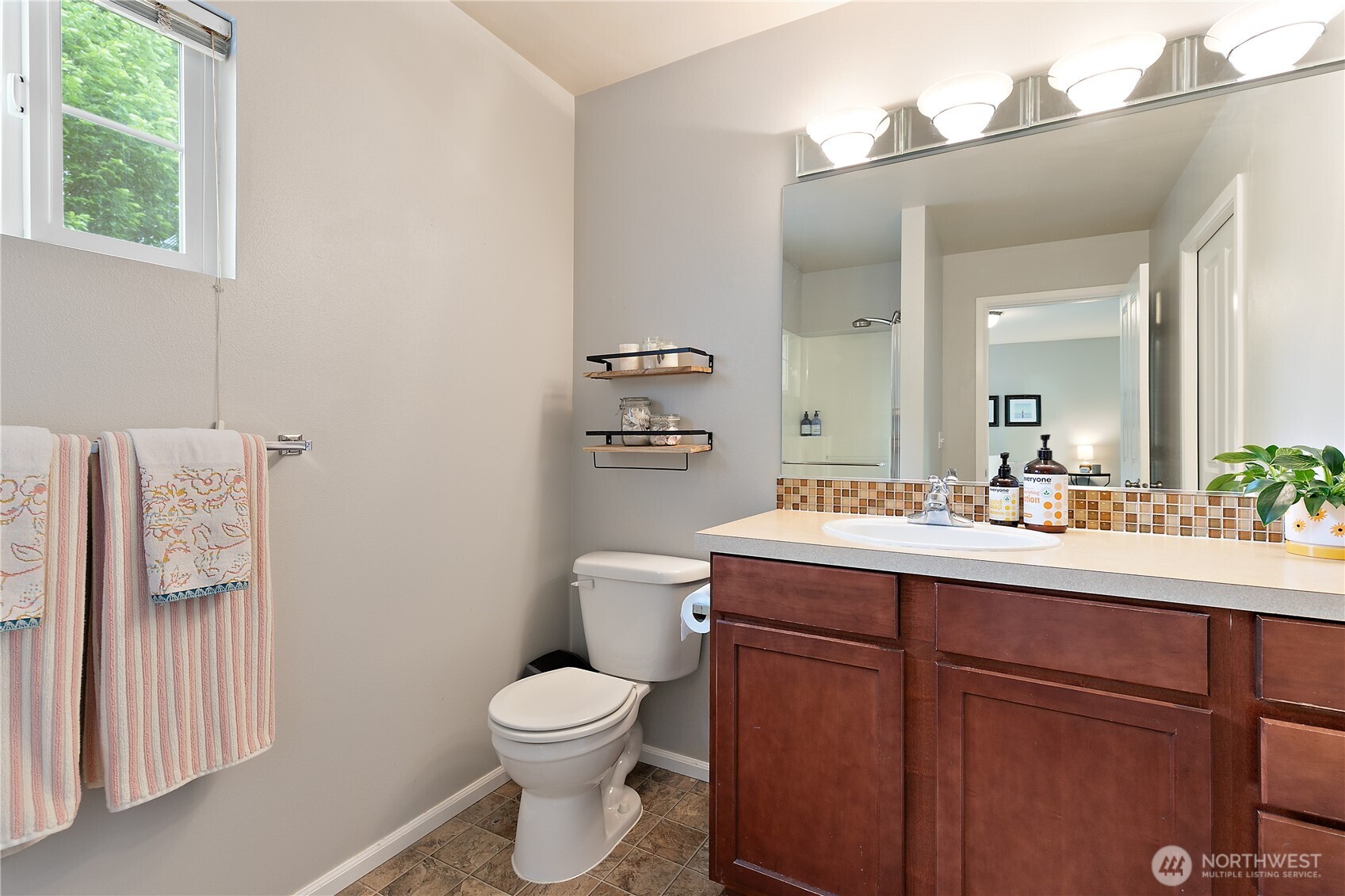 6600 Indiana Street Southeast Lacey, WA 98513 - Photo 14 of 21 a bathroom with a toilet a sink a mirror and a window