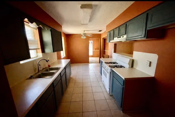 a kitchen with a sink a stove top oven a sink and a refrigerator