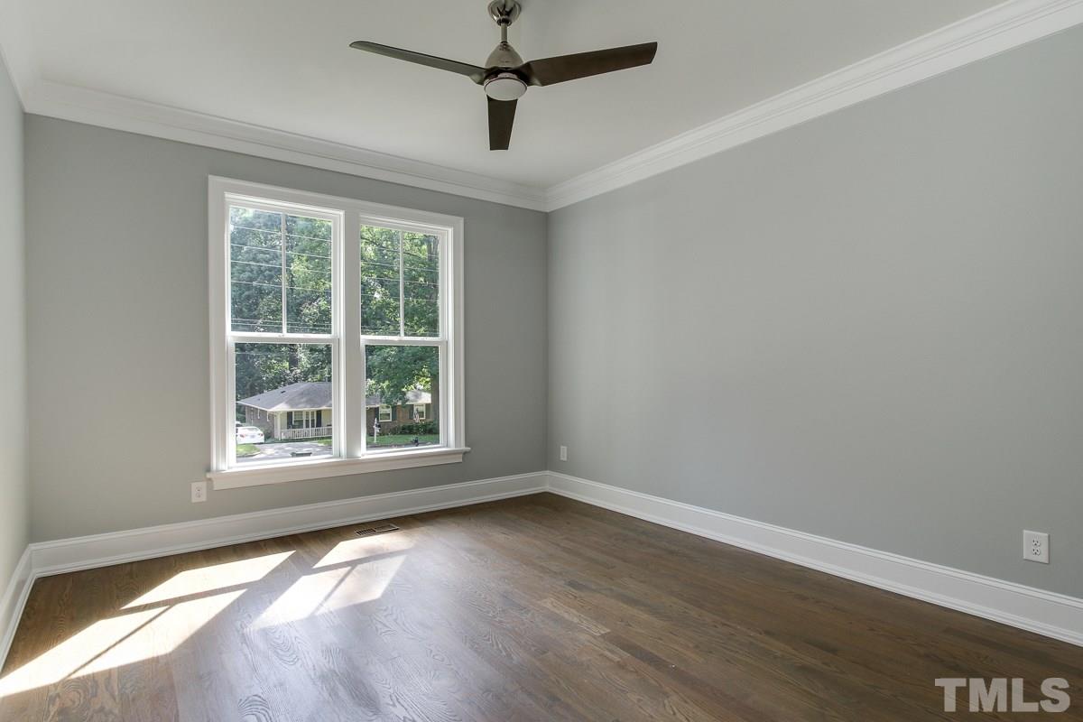 4913 Latimer Road Raleigh, NC 27609 - Photo 17 of 25 an empty room with wooden floor ceiling fan and windows