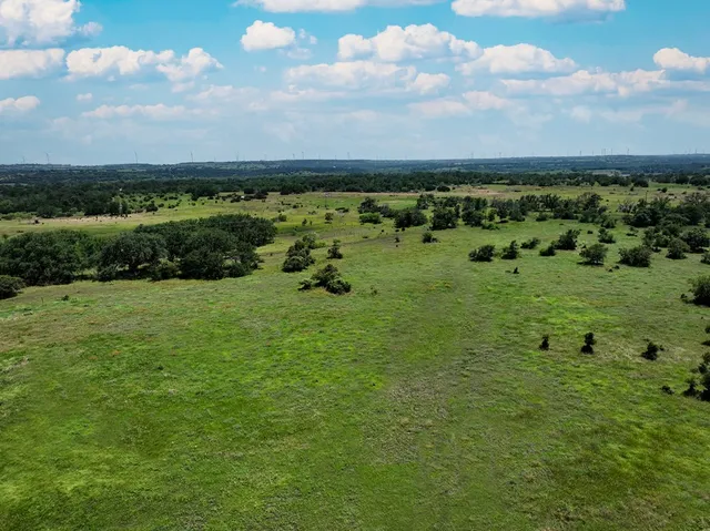 a view of a green field with an ocean