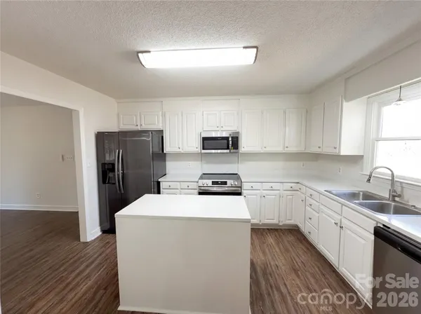 a kitchen with a refrigerator a sink and wooden cabinets