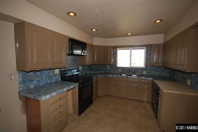 1095 Hot Springs Road Reno, NV 89521 - Photo 6 of 13 a kitchen with granite countertop a sink and a stove top oven