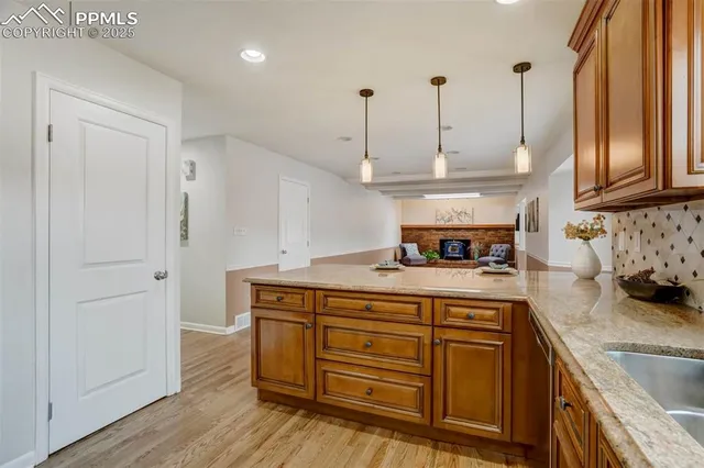 a kitchen with stainless steel appliances granite countertop a sink a stove and a wooden floors