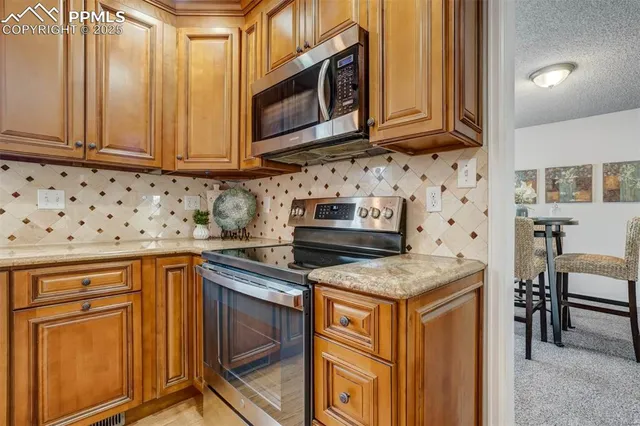 a kitchen with stainless steel appliances granite countertop a stove microwave and cabinets