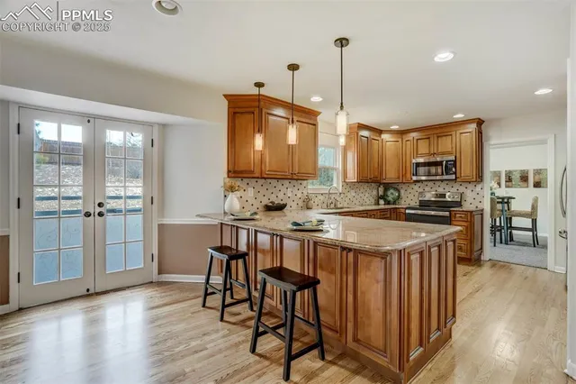 a kitchen with kitchen island granite countertop wooden floors and wooden cabinets
