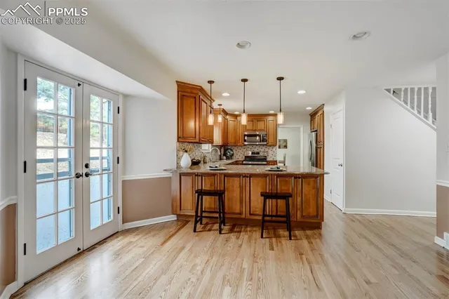 a kitchen with kitchen island wooden floors and refrigerator
