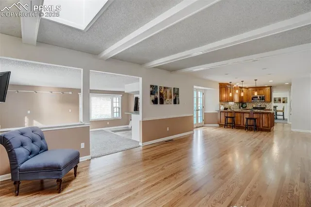 a living room with furniture and hard wood flooring