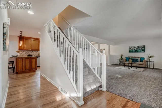 a view of a livingroom with wooden floor and furniture