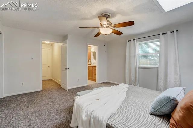 a bedroom with a large bed and ceiling fan