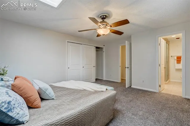 a bedroom with a large bed and ceiling fan