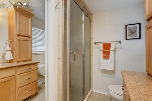 a bathroom with a granite countertop sink a toilet and shower