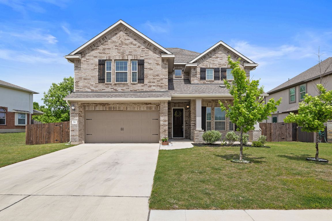 a front view of a house with a yard and garage