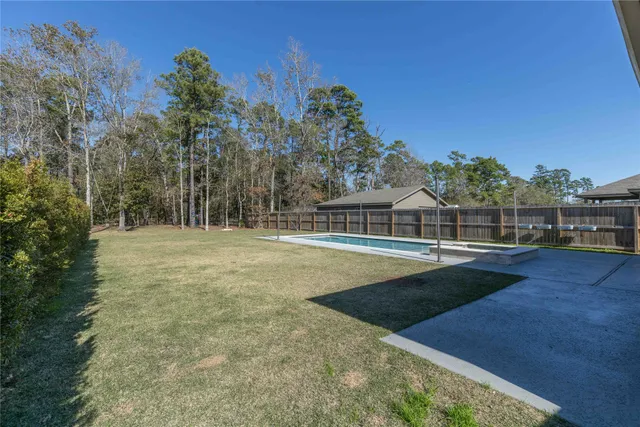 a view of wooden house with large trees and wooden fence