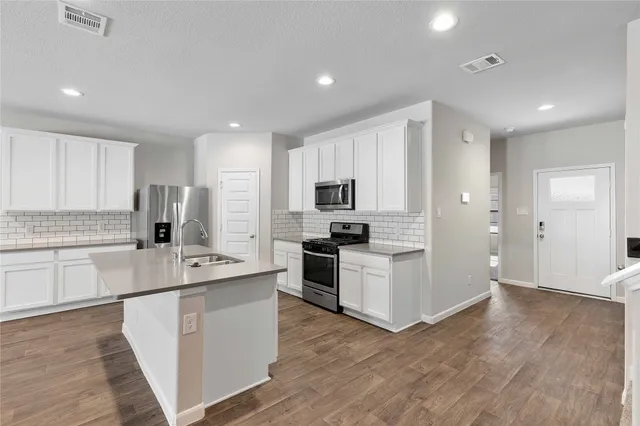 a kitchen with stainless steel appliances granite countertop a sink stove and refrigerator
