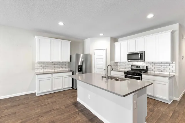 a kitchen with a sink cabinets and wooden floor