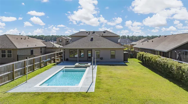 a view of a house with a backyard and a park