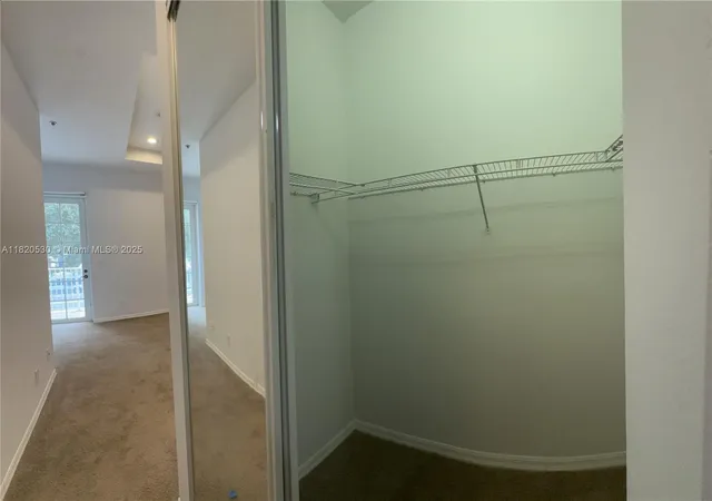 an empty room with windows and ceiling fan