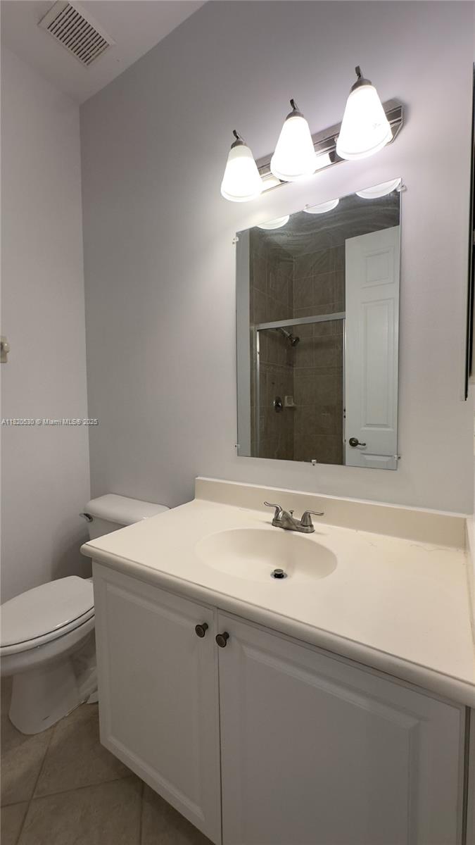 1587 Frederick Small Road Jupiter, FL 33458 - Photo 23 of 30 a bathroom with a sink a toilet and a mirror