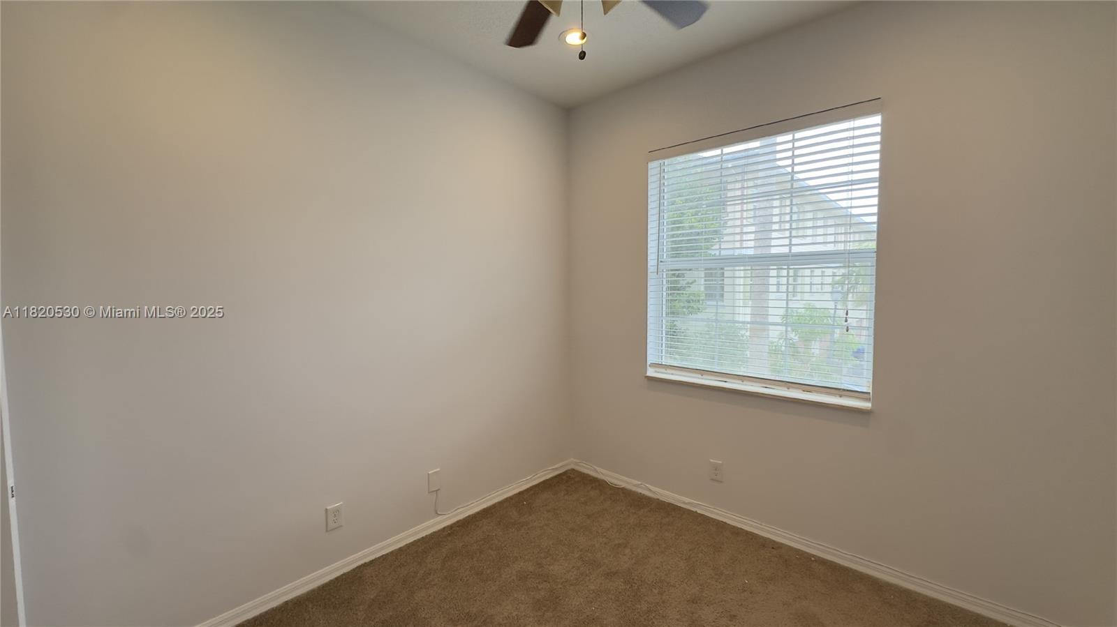 1587 Frederick Small Road Jupiter, FL 33458 - Photo 25 of 30 an empty room with a window and a ceiling fan