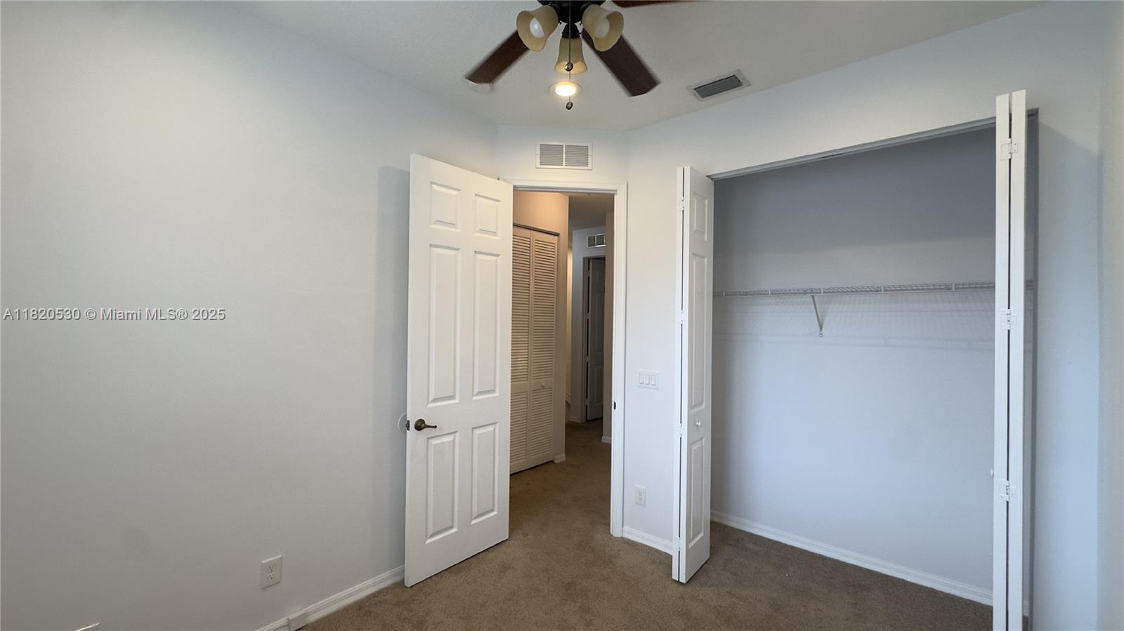 1587 Frederick Small Road Jupiter, FL 33458 - Photo 26 of 30 an empty room with closet and a chandelier fan