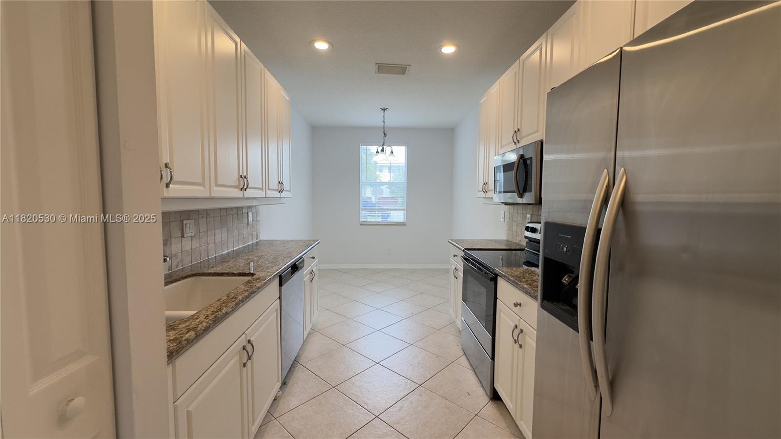 1587 Frederick Small Road Jupiter, FL 33458 - Photo 5 of 30 a kitchen with kitchen island granite countertop a sink stove and refrigerator