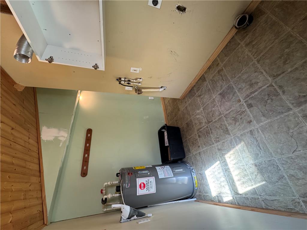 134 Bear Road Kunkletown, PA 18058 - Photo 24 of 42 Functional utility space includes built-in cabinetry, durable tile flooring, and wood paneling details.
