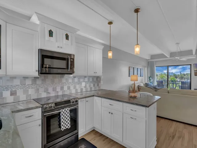 a kitchen with granite countertop a stove sink and microwave