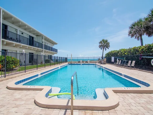 a view of a swimming pool with potted plants