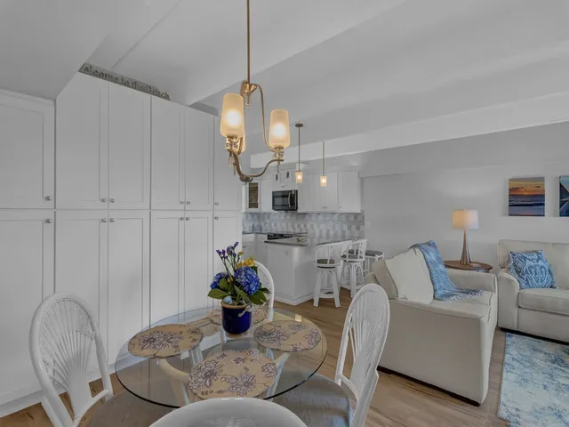 a living room with furniture a dining table and a chandelier