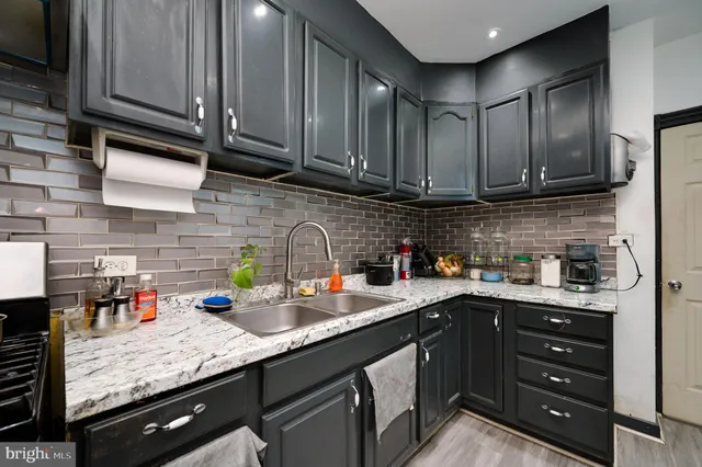 a kitchen with stainless steel appliances granite countertop a sink a stove and cabinets